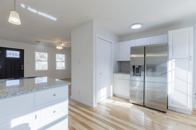 kitchen featuring ceiling fan, stainless steel fridge with ice dispenser, decorative light fixtures, decorative backsplash, and white cabinets