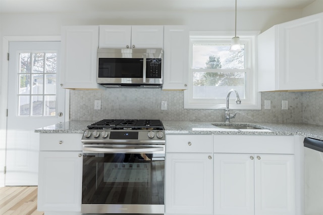 kitchen featuring white cabinets, stainless steel appliances, tasteful backsplash, and sink