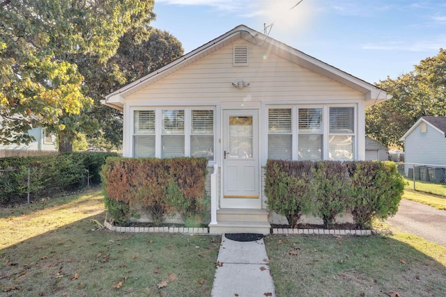 bungalow-style home featuring a front lawn