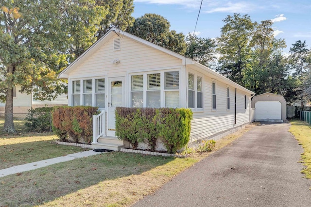 view of front of house with an outbuilding, a front lawn, and a garage