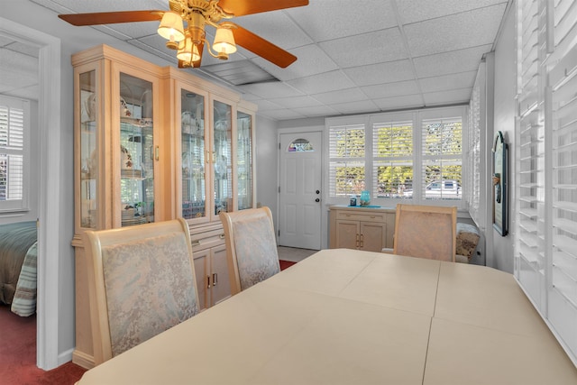 dining area with a paneled ceiling, ceiling fan, and a wealth of natural light