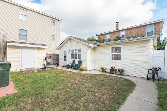 rear view of house featuring a patio area and a yard