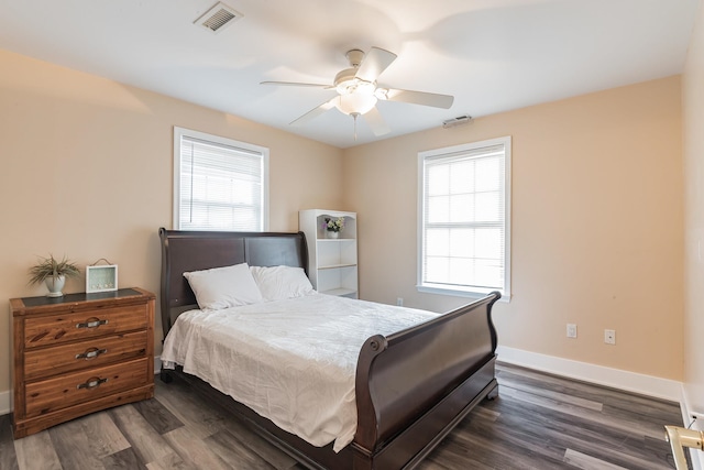 bedroom with multiple windows, ceiling fan, and dark wood-type flooring