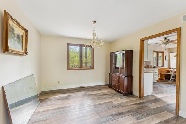 57 Somers Ave, Seaville, NJ 08230 - unfurnished dining area with a chandelier, light wood-style flooring, baseboards, and a ceiling fan