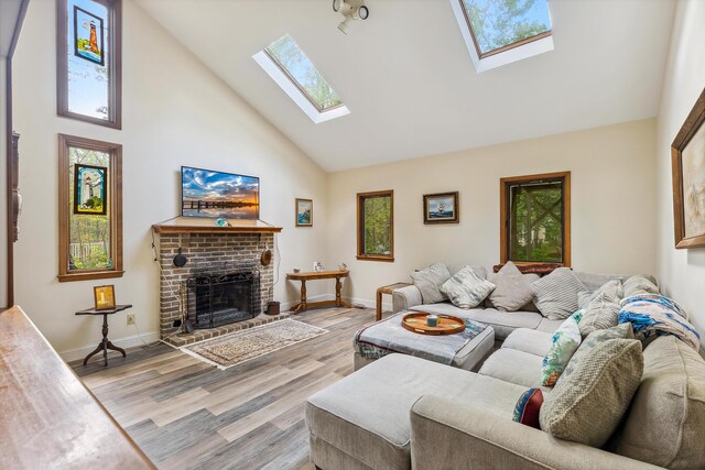 57 Somers Ave, Seaville, NJ 08230 - living area with high vaulted ceiling, a skylight, a fireplace, light wood finished floors, and baseboards