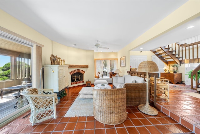 living room with dark tile patterned flooring, a brick fireplace, and ceiling fan