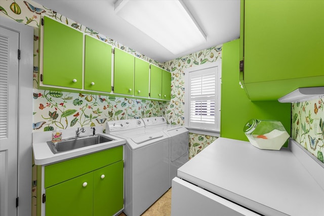 clothes washing area with cabinets, washing machine and clothes dryer, and sink