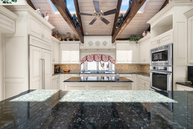 kitchen with dark stone counters, built in appliances, tasteful backsplash, white cabinetry, and wood ceiling