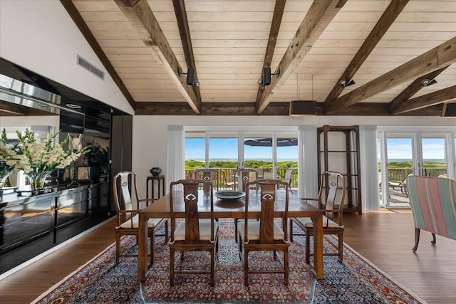 dining space with beam ceiling, hardwood / wood-style flooring, and wood ceiling