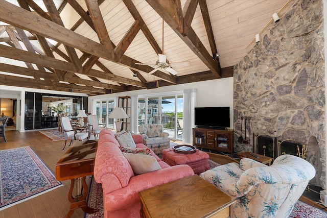 living room featuring high vaulted ceiling, ceiling fan, a fireplace, beam ceiling, and wood-type flooring