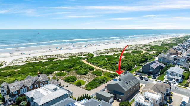 birds eye view of property featuring a beach view and a water view