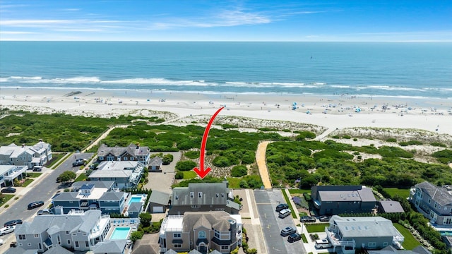 bird's eye view featuring a water view and a beach view