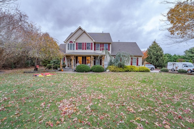 colonial home with a front yard and a porch