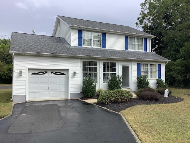 view of property featuring a garage and a front yard