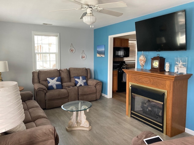 living room with ceiling fan and wood-type flooring