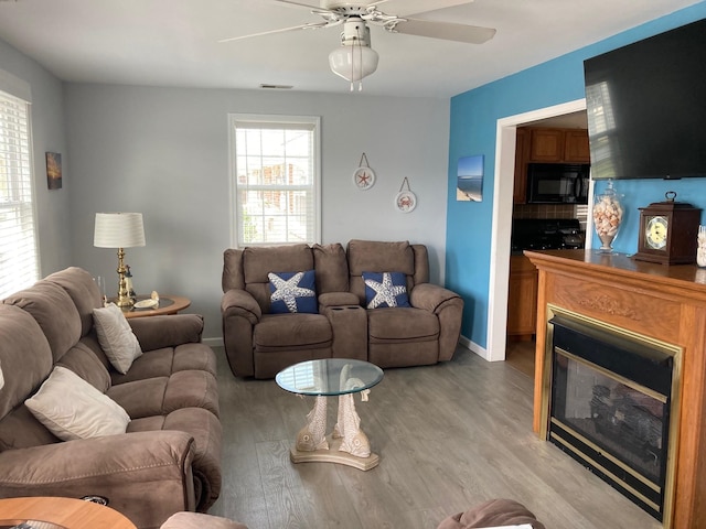 living room featuring ceiling fan and light hardwood / wood-style flooring