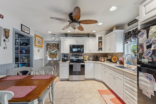 kitchen with black appliances, light tile patterned flooring, a sink, ceiling fan, and light countertops