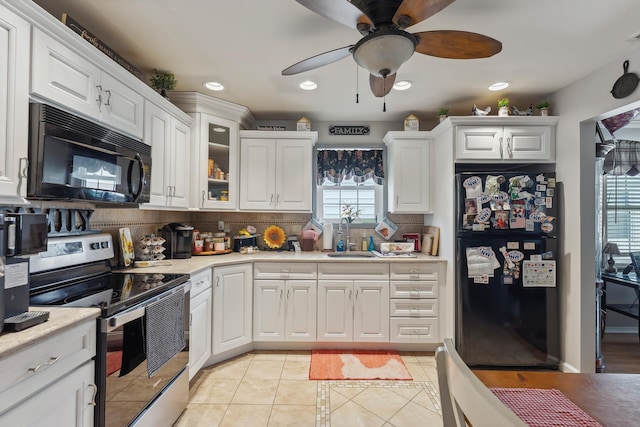 kitchen with black appliances, a sink, a ceiling fan, light tile patterned flooring, and backsplash