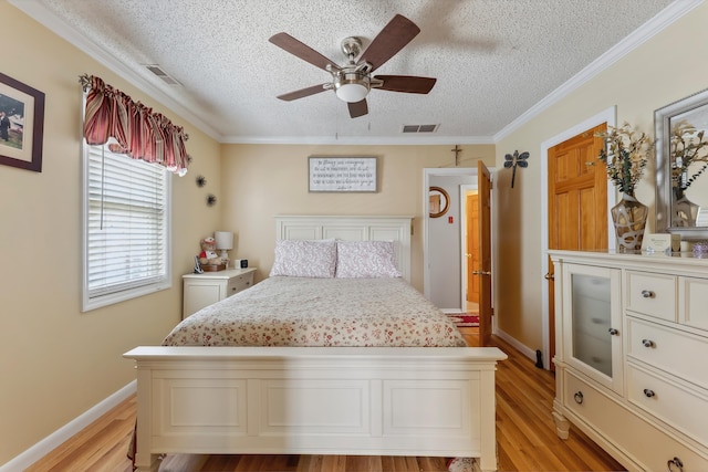 bedroom with light wood-style flooring, a textured ceiling, ornamental molding, ceiling fan, and baseboards