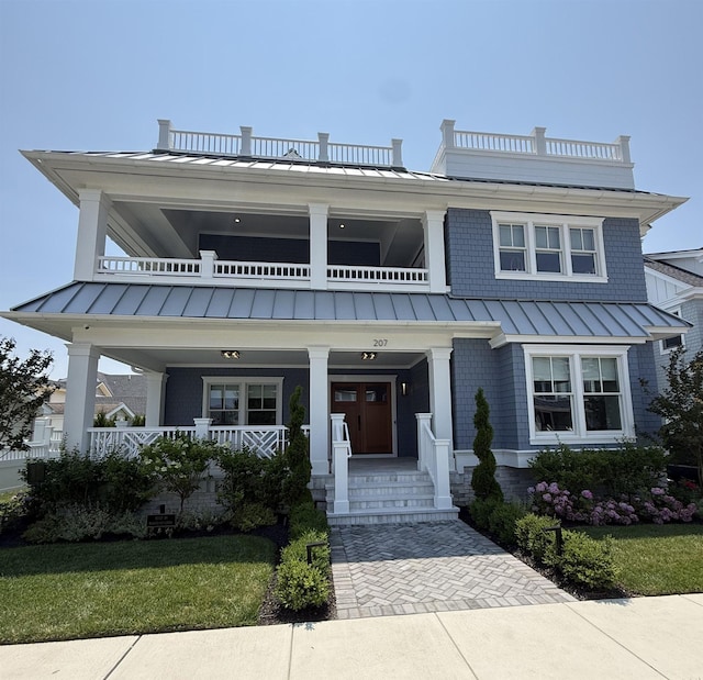 207 120th St, Stone Harbor, NJ 08247 - view of front of house with a standing seam roof, a balcony, a metal roof, covered porch, and a front lawn