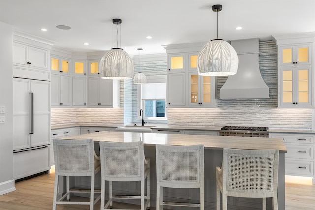 207 120th St, Stone Harbor, NJ 08247 - kitchen with paneled built in refrigerator, custom range hood, light countertops, decorative backsplash, and recessed lighting
