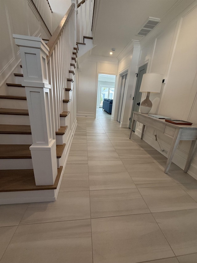 207 120th St, Stone Harbor, NJ 08247 - stairway featuring crown molding, a decorative wall, tile patterned flooring, and recessed lighting