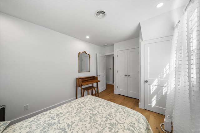 bedroom with visible vents, baseboards, a closet, light wood finished floors, and recessed lighting