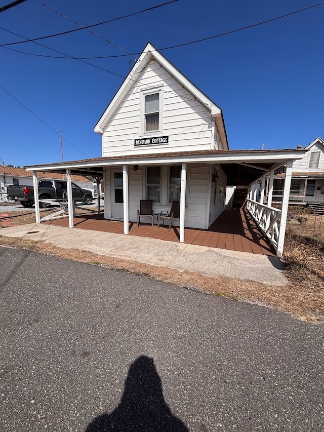 farmhouse inspired home featuring an attached carport and a porch