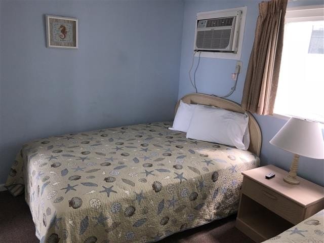 bedroom with dark colored carpet and an AC wall unit