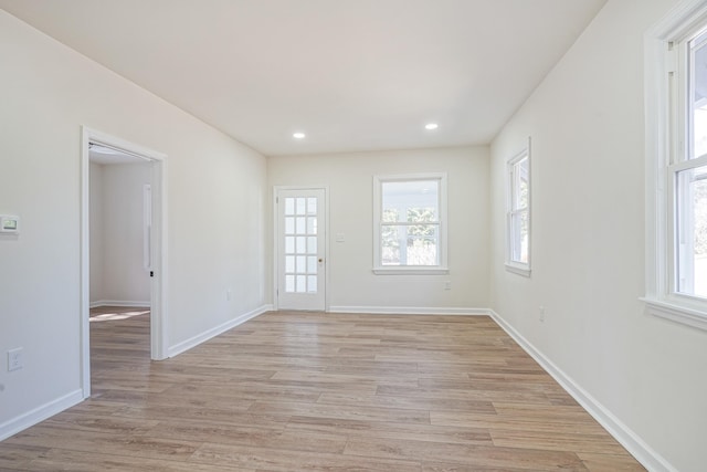 empty room with light wood-type flooring, baseboards, and recessed lighting