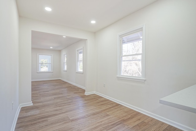 empty room featuring light wood-style flooring, baseboards, and recessed lighting