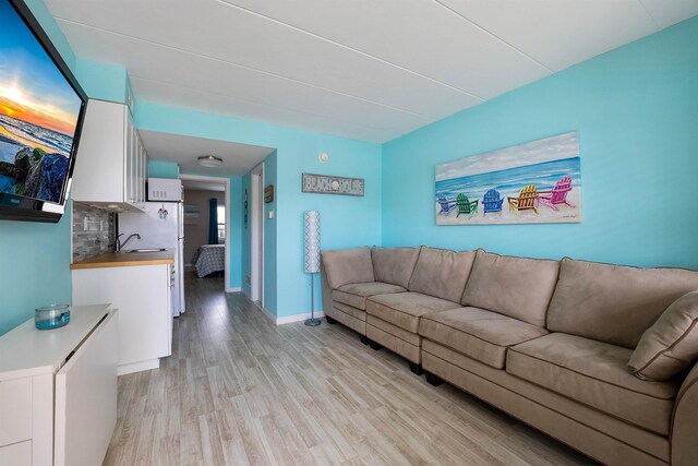 living room with light hardwood / wood-style floors and sink