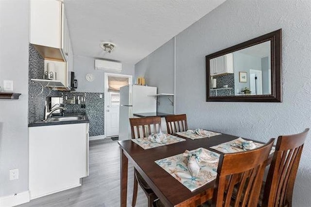301 E Lavender Rd Unit 2, Wildwood, NJ 08260 - dining room with wood finished floors, an AC wall unit, and a textured wall