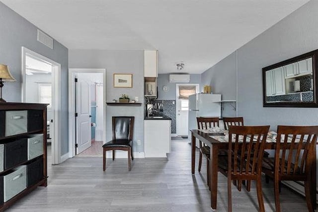 301 E Lavender Rd Unit 2, Wildwood, NJ 08260 - dining area featuring wood finished floors, plenty of natural light, and a wall mounted air conditioner