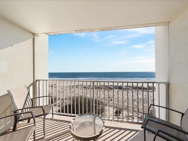 balcony featuring a water view and a view of the beach