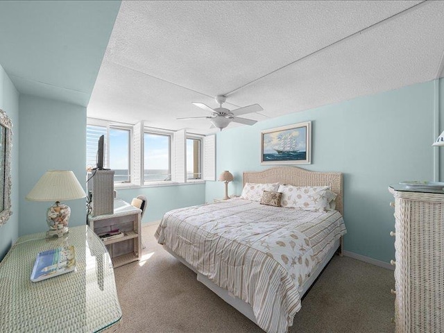 carpeted bedroom with ceiling fan and a textured ceiling