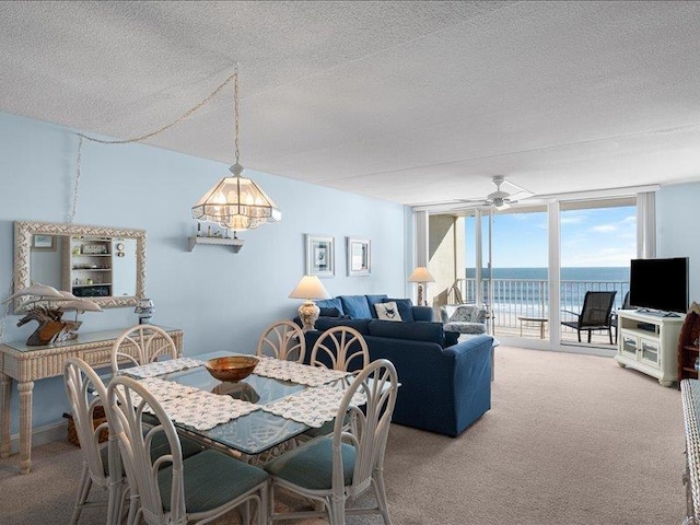 dining space with carpet flooring, a textured ceiling, ceiling fan, and expansive windows