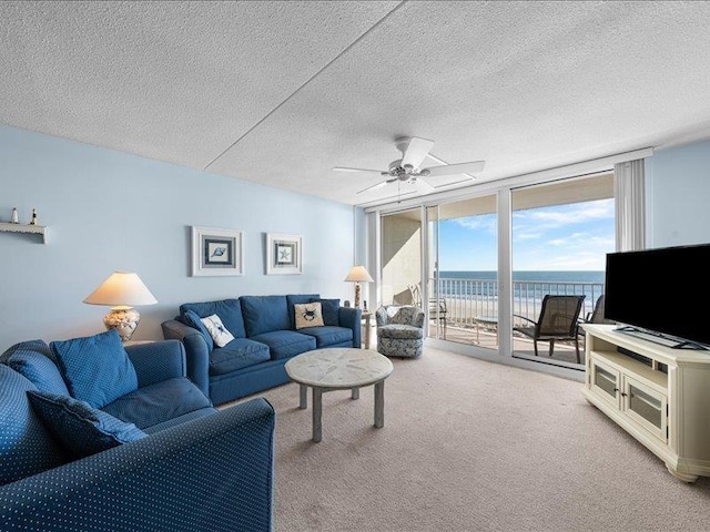 living room featuring a textured ceiling, ceiling fan, carpet, and expansive windows