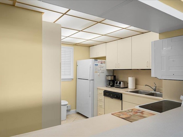 kitchen with white appliances, white cabinetry, sink, and light tile patterned floors