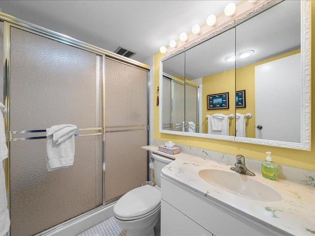 bathroom with toilet, an enclosed shower, tile patterned flooring, and vanity