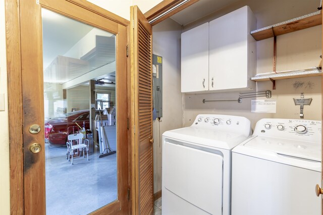 clothes washing area featuring electric panel, cabinet space, and washer and dryer