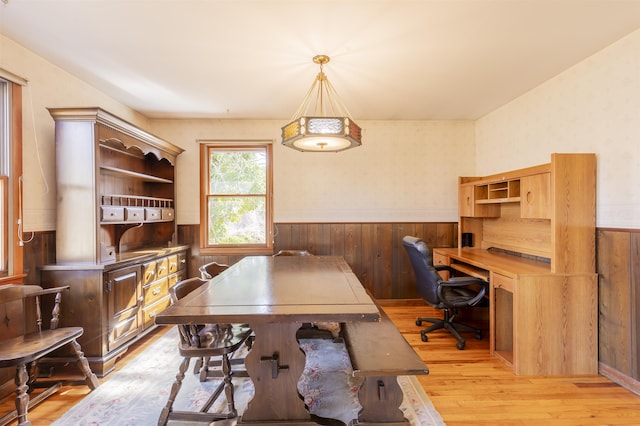 home office featuring a wainscoted wall, light wood-style floors, and wood walls