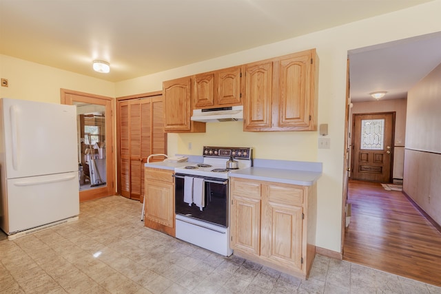 kitchen with under cabinet range hood, white appliances, light brown cabinetry, and light countertops