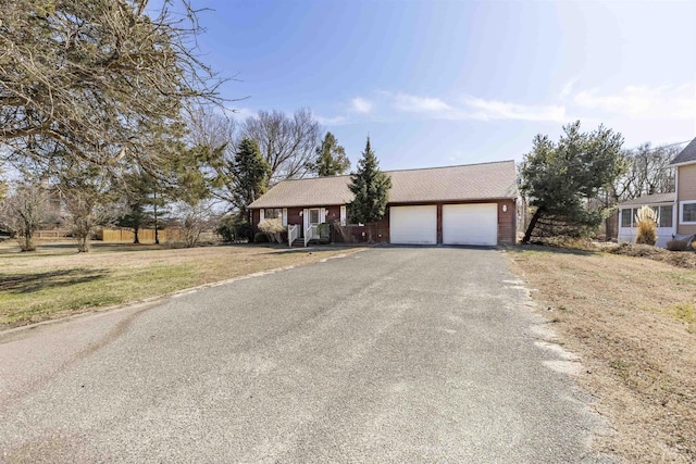 ranch-style house featuring driveway, a front yard, and a garage