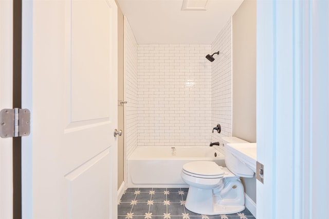 bathroom with tiled shower / bath combo and toilet