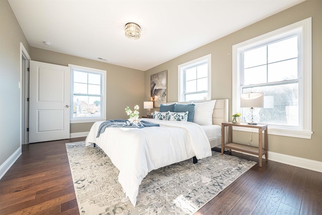 bedroom with dark hardwood / wood-style floors