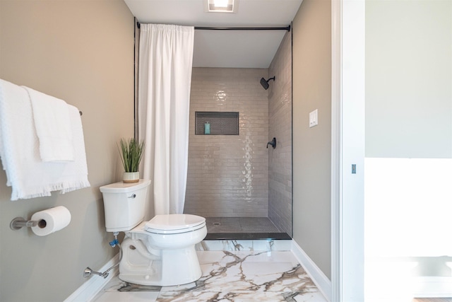 bathroom featuring a tile shower and toilet