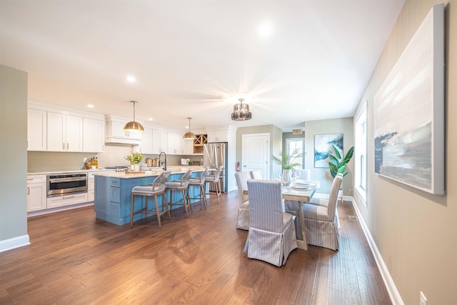 dining space with dark hardwood / wood-style floors and sink