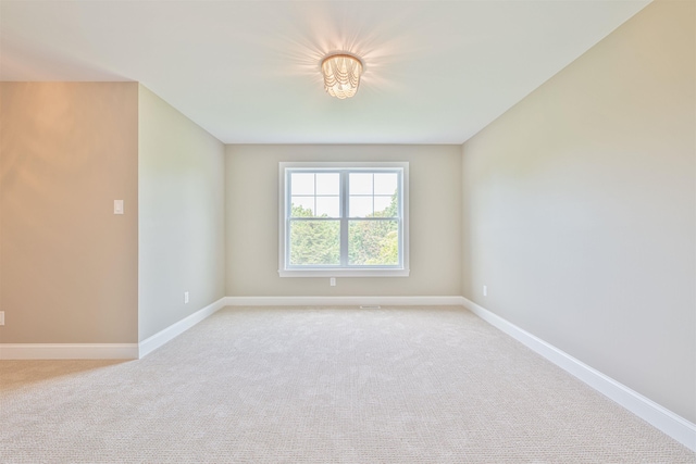 spare room featuring light carpet