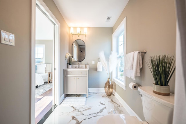 bathroom featuring vanity, toilet, and plenty of natural light